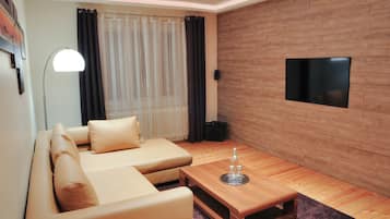 Apartamento Premium, vistas a la ciudad | Sala de estar | Televisión de pantalla plana de 48 pulgadas con canales por satélite