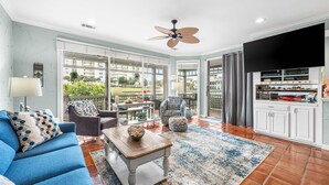 A spacious living area with a blue sofa, a wooden coffee table, and a patterned rug.