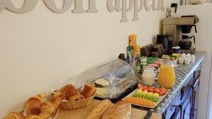 Un buffet de petit-déjeuner avec des croissants, du pain et des fruits.