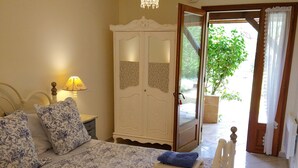 Une chambre à coucher comprenant un lit, une armoire et une porte donnant sur l’extérieur.
