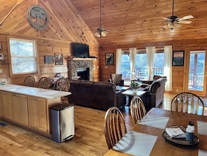 Un intérieur de chalet chaleureux comprenant une cuisine, un coin repas et un salon.