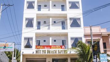 Un hotel a più piani con un cartello che riporta la scritta "MUI NE BEACH HOTEL".