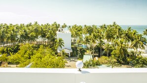 Un resort con piscina, palme e vista sull'oceano.