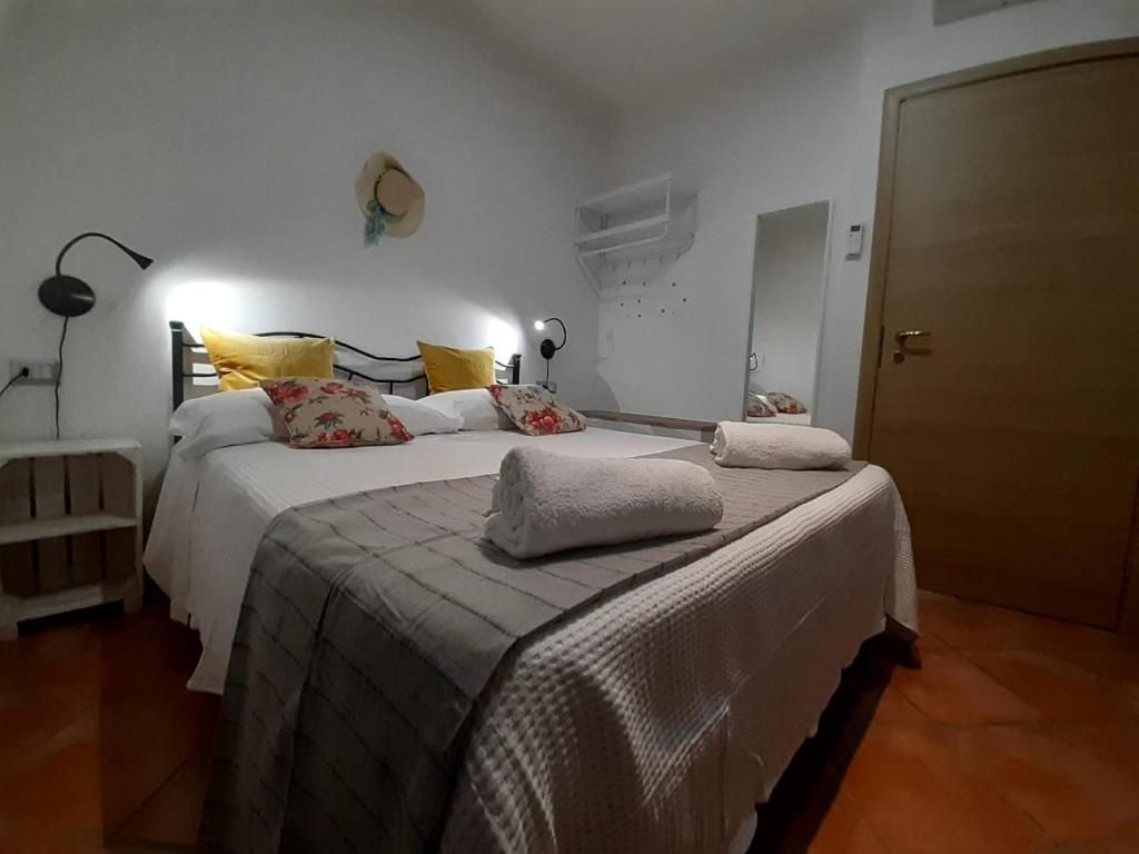 Un dormitorio con cama, mesitas de noche, armario y aire acondicionado de pared.