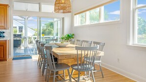 A spacious kitchen with a large island, wooden flooring, and a view of the outdoors. - Water's Edge - Amazing Sunset Views and Short Walk to the Beach. (Isle of Palms)