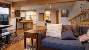 Una sala moderna con un sofá, una mesa de comedor y una zona de cocina.