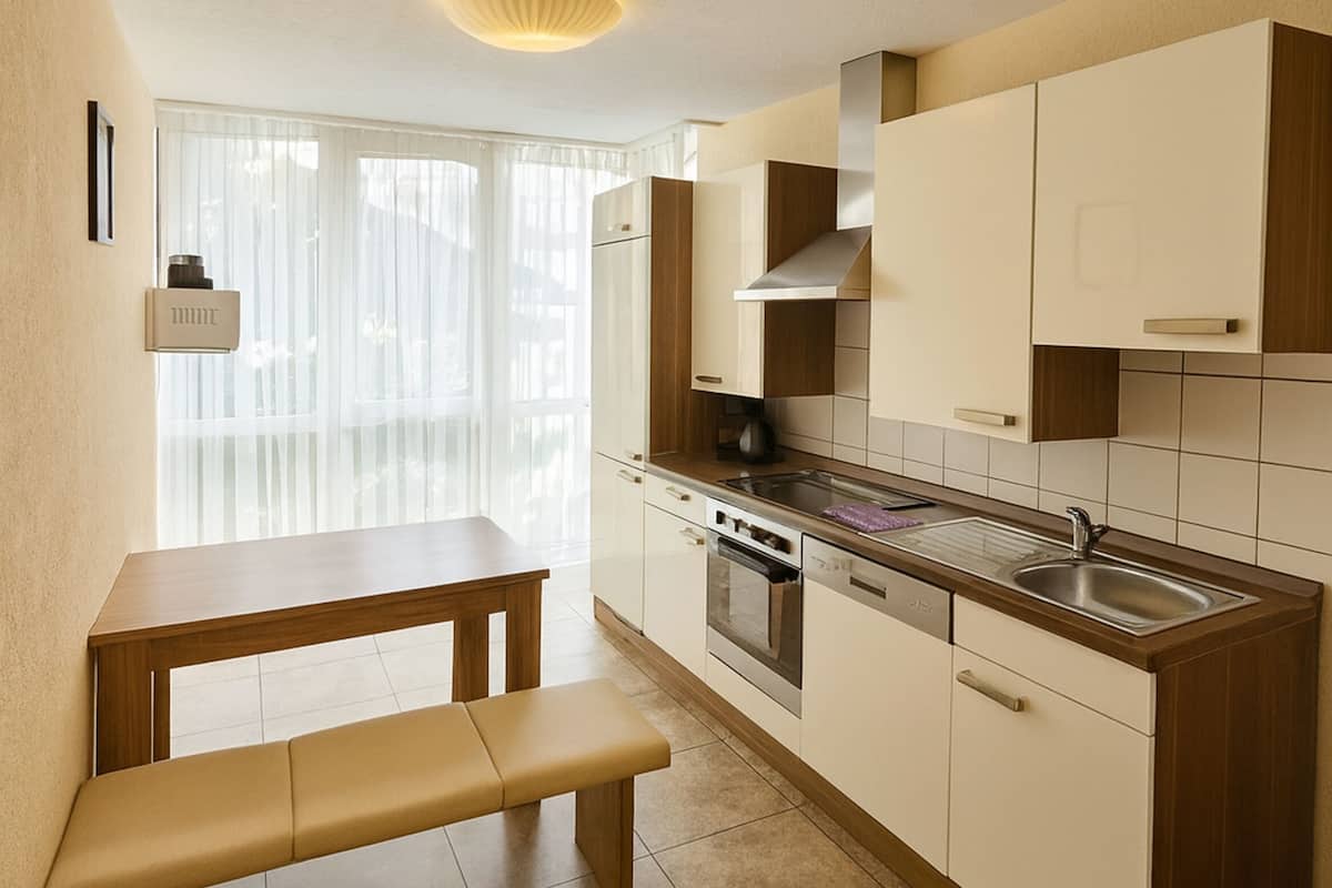 A compact kitchen with a bench, a stove, a dishwasher, and a sink.