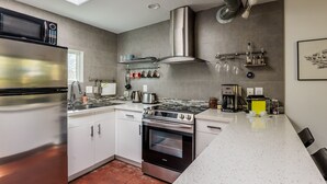 A modern kitchen with stainless steel appliances, a gas stove, and a built-in oven. - Studio Guesthouse In Resort Setting (Phoenix)