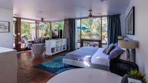 A modern bedroom with a large bed, a desk, and a TV. - Studio Guesthouse In Resort Setting (Phoenix)