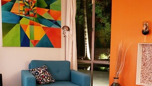 A modern living room with a blue sofa, a colorful abstract painting, and a wooden coffee table. - A Mid-Century Modern Alexander Home Oasis (Lively Music-Themed Decor). (Palm Springs)