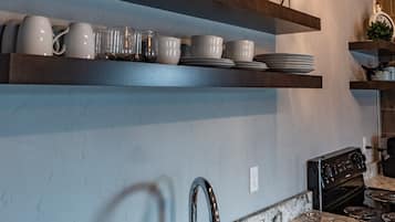 Een koelkast, een oven, kookgerei, borden en bestek