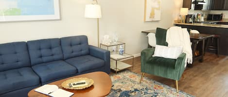 A living room with a blue sofa, a small wooden coffee table, and a patterned rug.