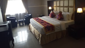 A hotel room with a bed, bedside lamps, a desk, and a chair. - Glo-ran Hotel and Event Place (Owerri)