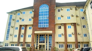 A multi-story hotel with a prominent arched window and a sign reading "GLO-RAN". - Glo-ran Hotel and Event Place (Owerri)
