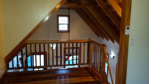 Un escalier en bois, doté d’une rampe, menant à un palier.