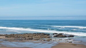 Una playa con formaciones rocosas y olas.
