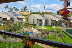 A hotel with multiple buildings, a swimming pool, and palm trees.