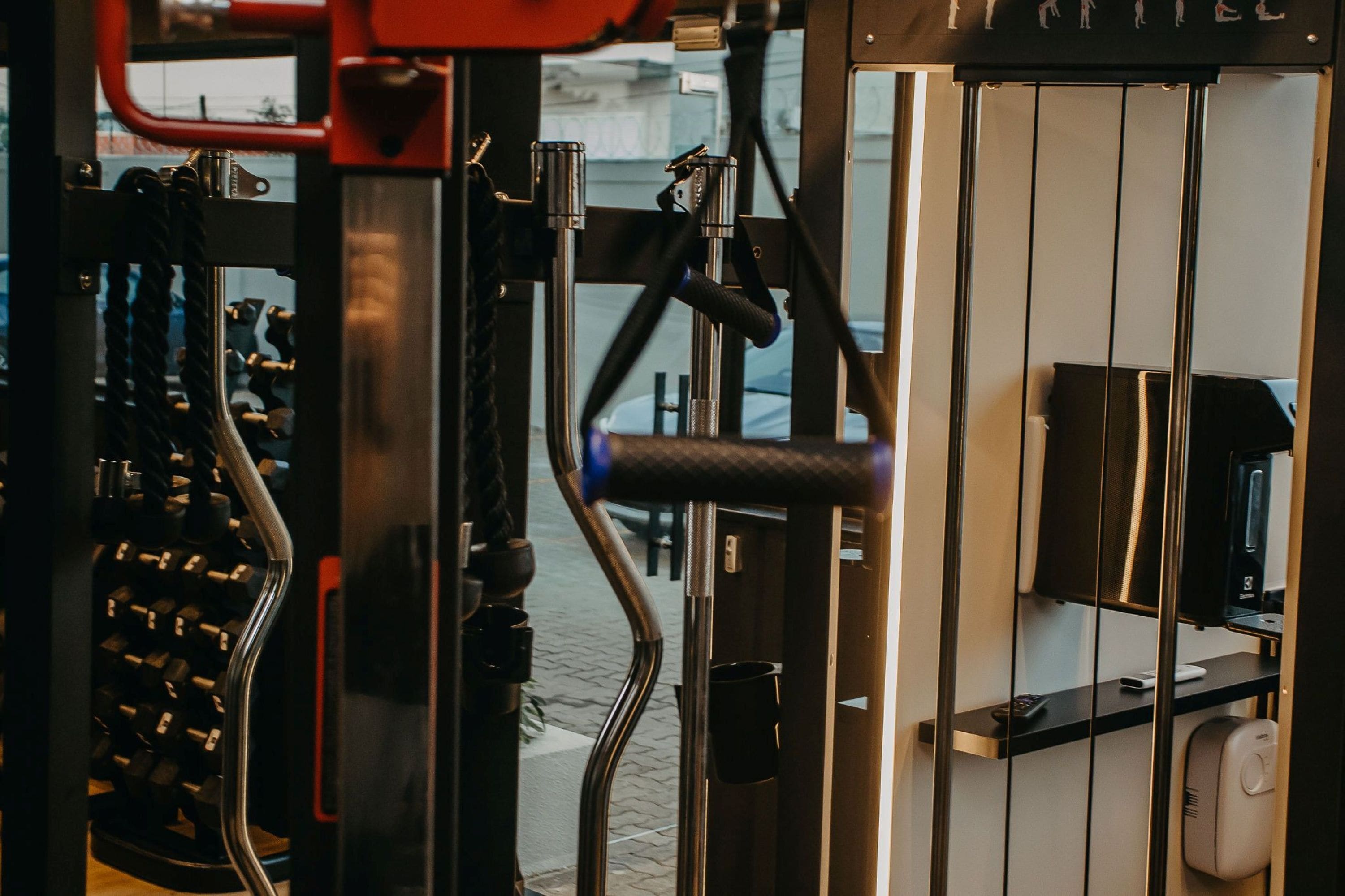 A gym with exercise equipment, a television, and a counter with a phone and a cup.