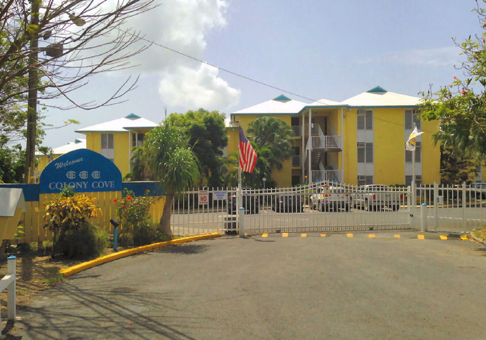 Une entrée fermée par un portail mène à un immeuble sur lequel on peut lire : « Bienvenue à Colony Cove ».