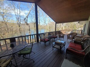 A covered deck with outdoor furniture, a table, and chairs. - Sparky's-Lakefront, Beautiful Shoreline- Close to Swim Pool & Marina! (Garfield)