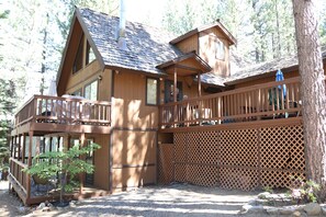 A wooden cabin with a balcony, a covered porch, and a view of the surrounding forest. - Stunning Alpine Retreat in South Lake Tahoe! (South Lake Tahoe)