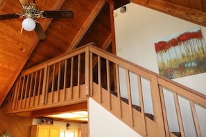A wooden staircase with a railing, a ceiling fan, and a painting on the wall. - Stunning Alpine Retreat in South Lake Tahoe! (South Lake Tahoe)