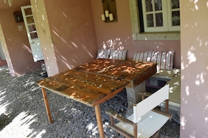 Relax in this charming outdoor seating area with a wooden table and cushioned benches.