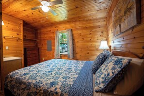 A wooden cabin bedroom with a bed, dresser, and ceiling fan. - Mountaineer Cabin 3 - Hot Tub & Fireplace close to New River Gorge National Park (Hico)