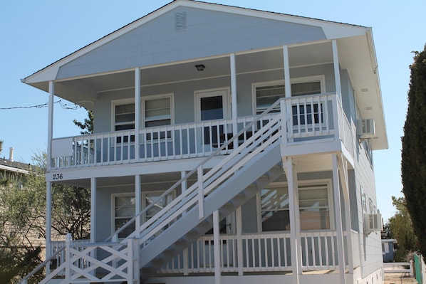 A two-story building with a balcony on the upper floor, a staircase leading to the upper level, and a number '236' visible on the lower level.
