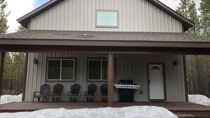 A building with a covered porch, multiple windows, and a door. - #1 Beautiful Cabin In The Heart Of Island Park (Island Park)
