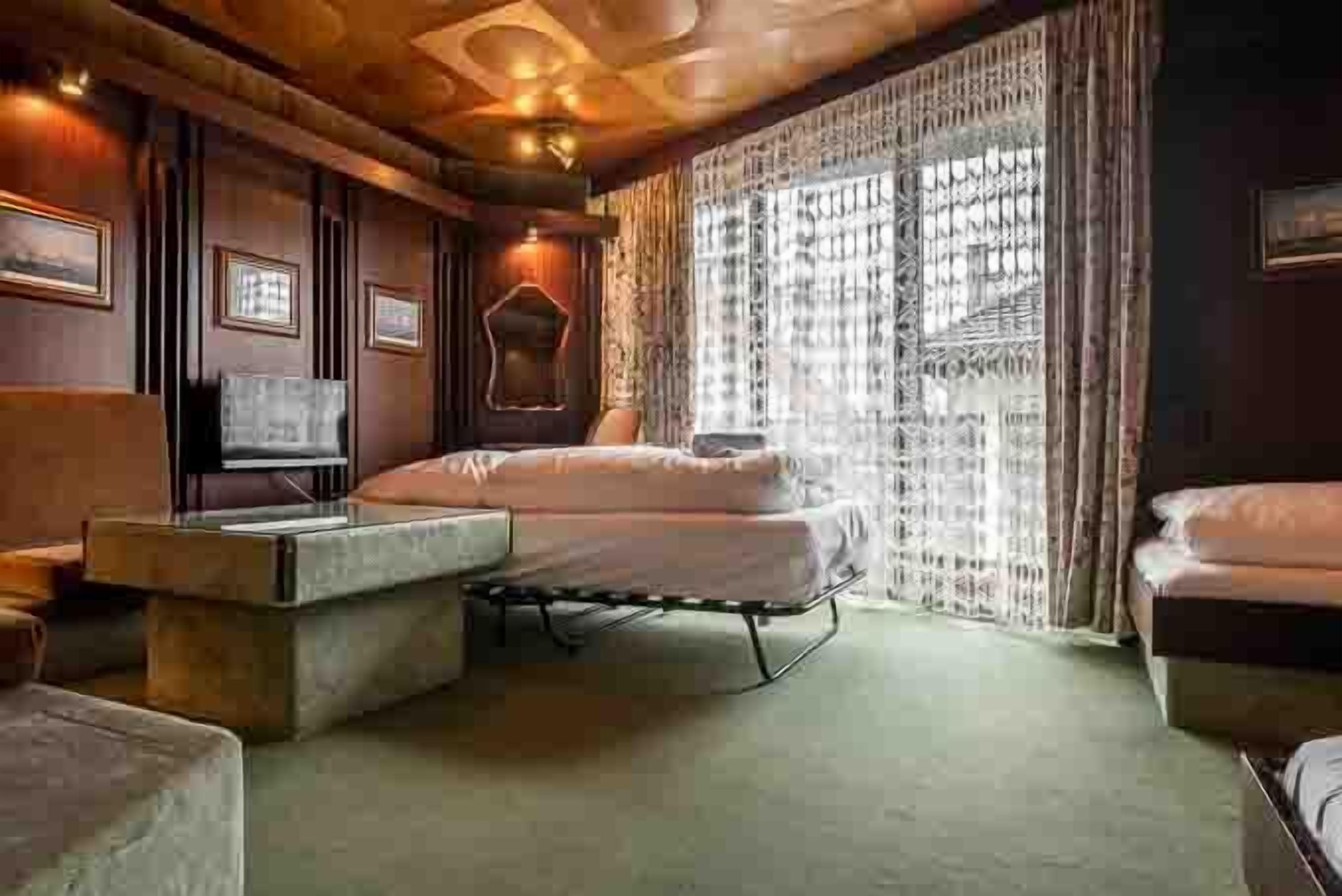 A room with a bed, a small table, and a television.