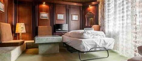 Un dormitorio acogedor con cama, mesitas de noche y una lámpara.