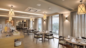 Un comedor moderno con mesas redondas, sillas e iluminación colgante.