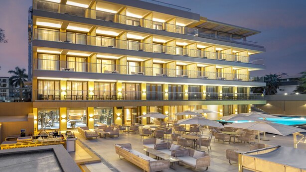 Un hotel de varios pisos con terraza al aire libre y piscina.