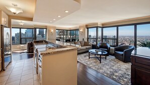 A modern living room with a kitchen, large windows, and a city view. - LOCATION!!  2b/2b Condo, 51st Floor AMAZING Views, Pool and other Amenities! (Chicago)