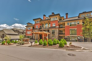 A multi-story hotel with a covered entrance, outdoor seating, and landscaped gardens. - 2BR Ski-in-Out Condo with Pool (Park City)