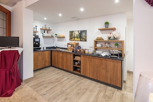 Una cocina moderna con armarios de madera, una isla central y varios electrodomésticos.