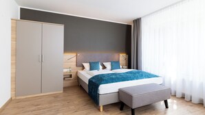 Una habitación de hotel moderna con cama, mesita de noche y armario.