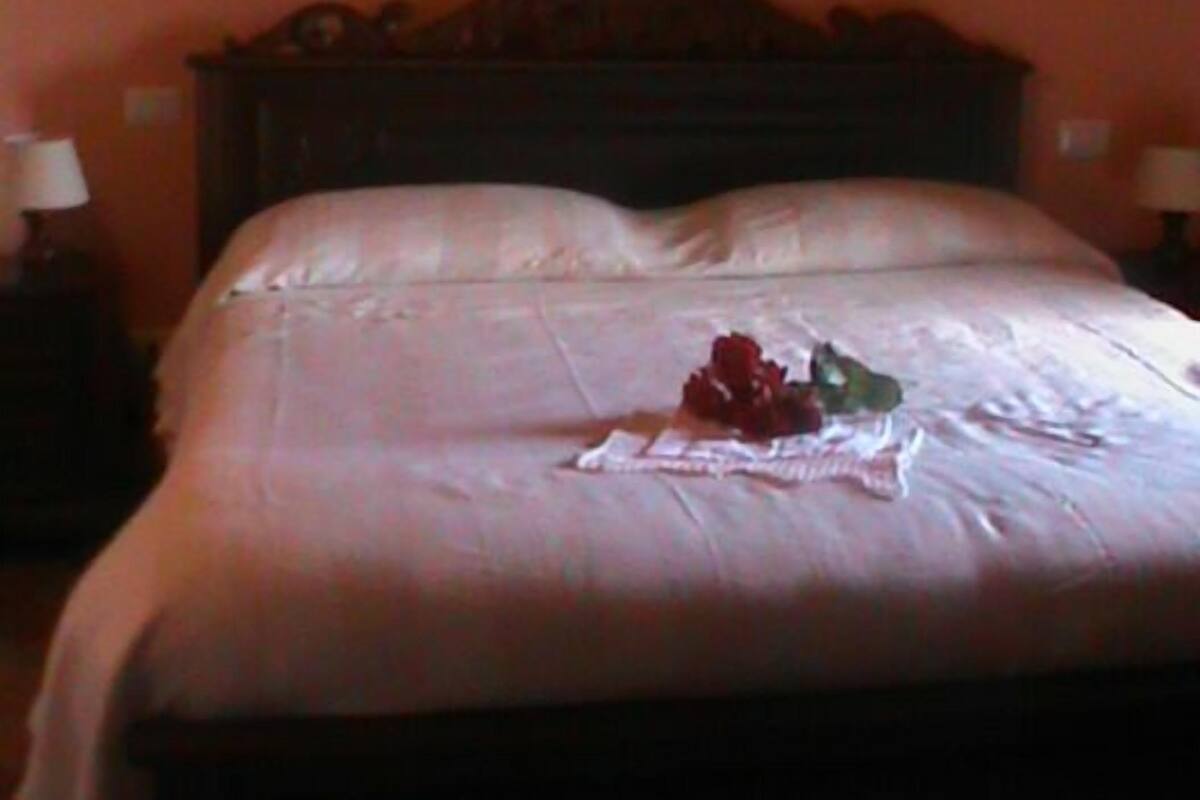 Une chambre à coucher avec un lit, une table de chevet et un tableau accroché au mur.