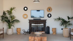 A living room with a TV, fireplace, and decorative mirrors. - Stylish Sicilian Villa with private pool near the Beach. (ispica)