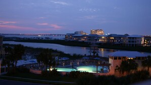 A waterfront hotel with a swimming pool, a dock, and a view of the river.