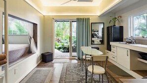 A compact kitchen with a dining area, a ceiling fan, and a view of greenery outside. - NEW! PonoMana Oasis - The Koi Cottage (Captain Cook)