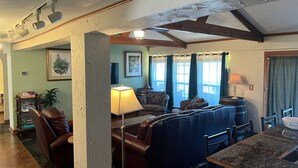 A living room with a sofa, chairs, a table, and a lamp. - Lakefront Retreat on 14+ Acres | Unforgettable Lake Getaway (Little Elm)