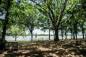 A park with picnic tables, benches, and a view of a lake.