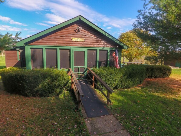 A wooden lodge with a green roof and a sign reading "Fullbrook's Lodge".