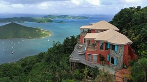 Ein Küstenhaus mit einem Balkon mit Blick auf eine Bucht und Boote.