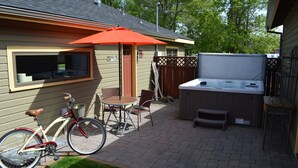A patio with a hot tub, a bicycle, and outdoor furniture. - Historic Downtown Location │Heart of Bend │Walk Everywhere │Hot Tub │High Demand (Bend)
