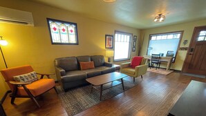 A living room with a sofa, armchairs, a coffee table, and a dining area with a table and chairs. - Historic Downtown Location │Heart of Bend │Walk Everywhere │Hot Tub │High Demand (Bend)