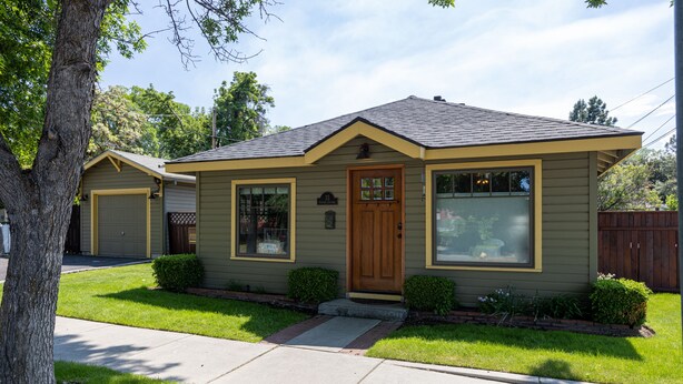A single-story house with a front porch, a garage, and a well-maintained lawn. - Historic Downtown Location │Heart of Bend │Walk Everywhere │Hot Tub │High Demand (Bend)