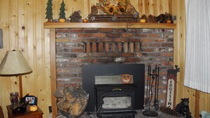 A rustic fireplace with a 'WELCOME' sign, surrounded by seasonal decorations like pine cones and pumpkins. - All The Comfort Of Home <br> Permit Number 0498 (South Lake Tahoe)